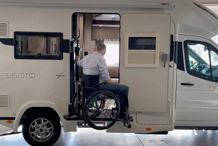 Rollstuhlfahrer wird per Seitenlift in ein Wohnmobil gehoben