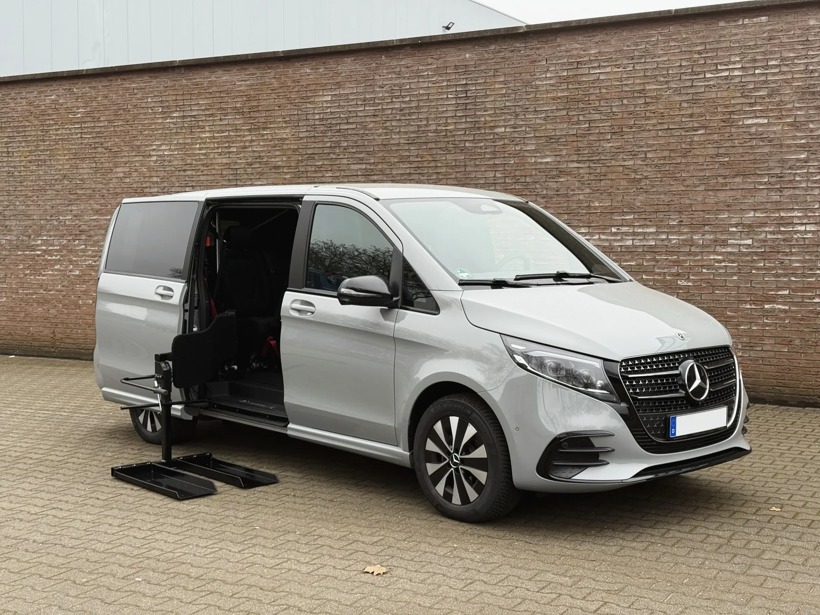 Rolpollo Rollstuhllift neben der Schiebetür eines Mercedes-Benz Personenbusses
